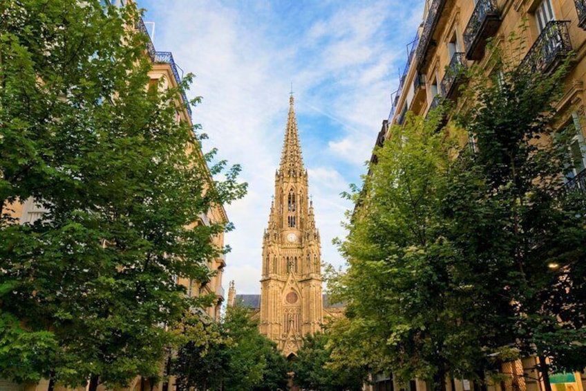 A cathedral with a tall spire, surrounded by trees and buildings. 2