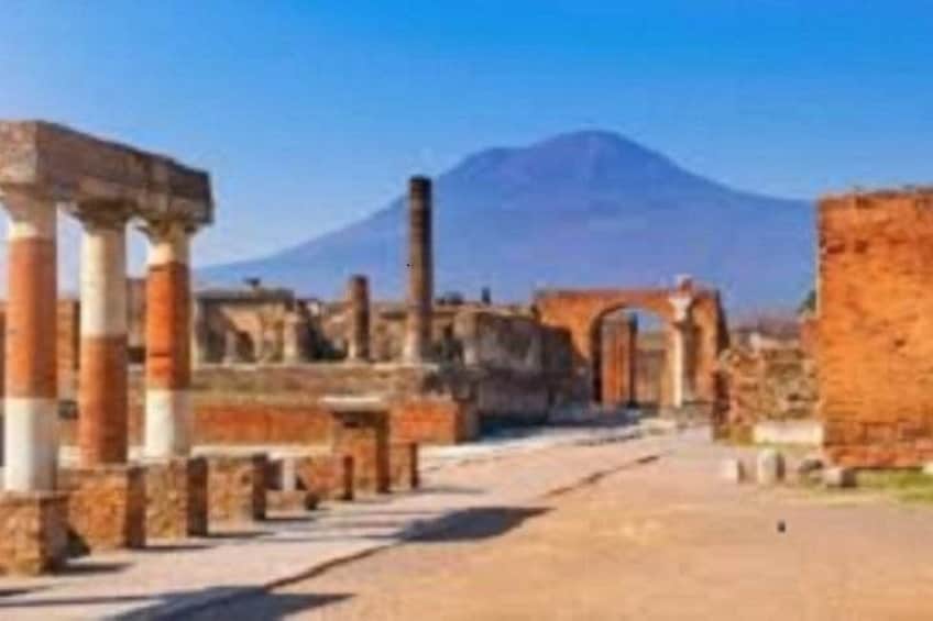 Ancient ruins with columns and a mountain in the background. 1