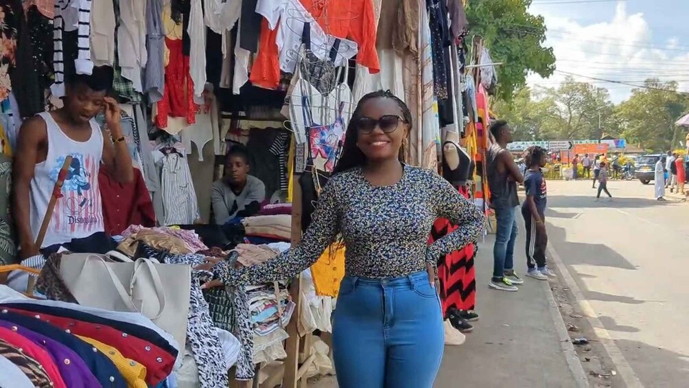 A street market with various clothing items on display. 1