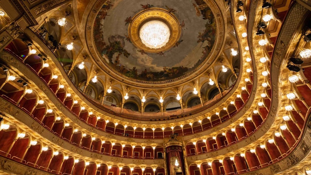 A grand, ornate theater with multiple balconies and a large, circular chandelier. 4