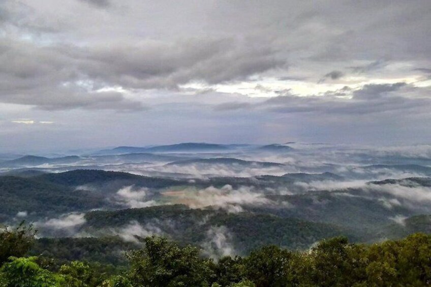 A mountainous landscape with a valley and a forested area. 4