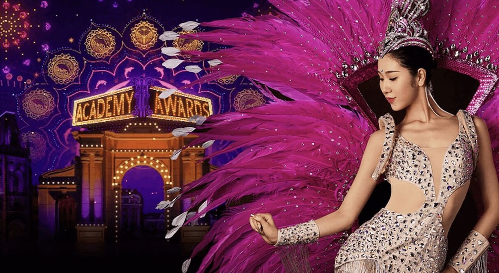 A person in a detailed costume with a 'Academy Awards' backdrop. 2