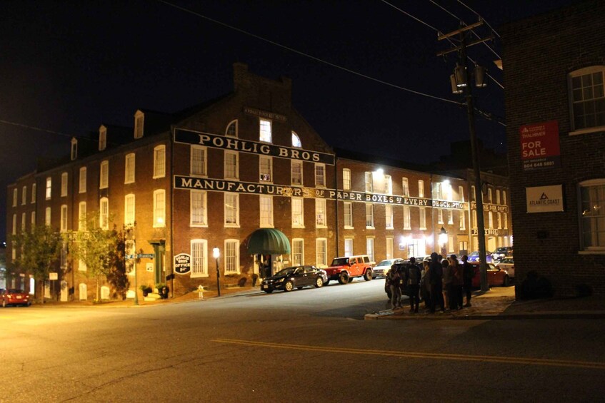 A historic building with illuminated signage reading "Pohlig Bros Manufacturers of Paper Boxes of Every Description." 3