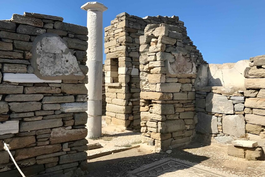 Ancient stone ruins with columns and patterned floor tiles. 4