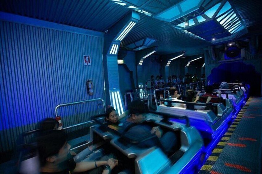 A ride with passengers seated in enclosed vehicles, moving along a track. 4