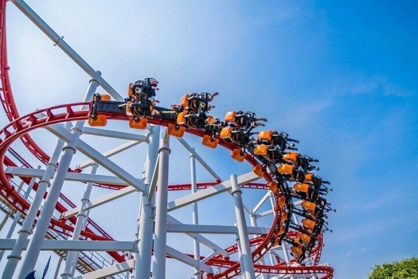 A roller coaster in motion with a clear sky in the background. 2