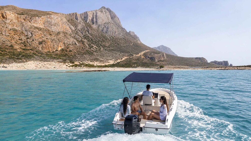 A boat on turquoise water with rocky mountains in the background. 3