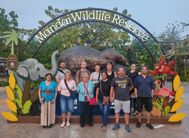 A group of people in front of the Mundi Wildlife Reserve sign with a large elephant sculpture. 2