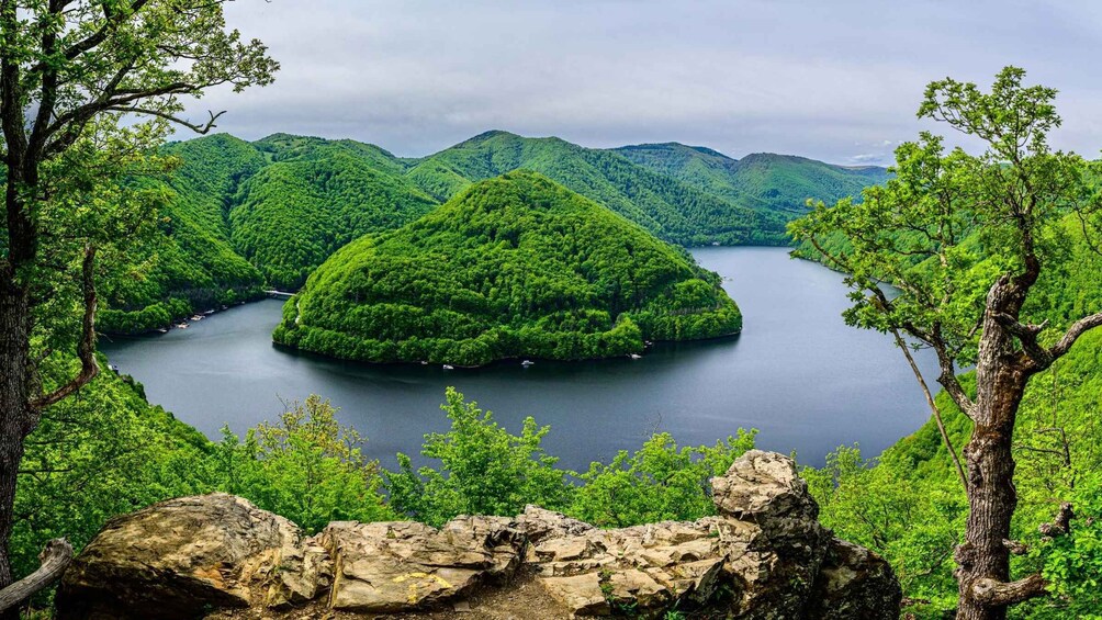 A lake surrounded by lush green hills. 1