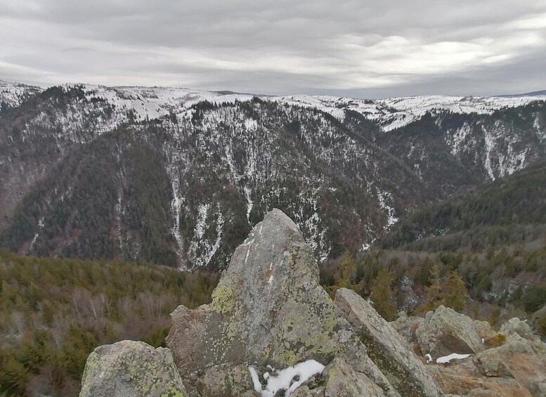 A snow-covered mountain range with a rocky foreground. 5