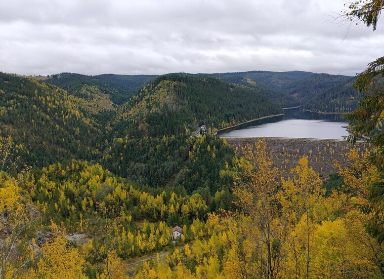 A lake surrounded by forested hills with autumn foliage. 4