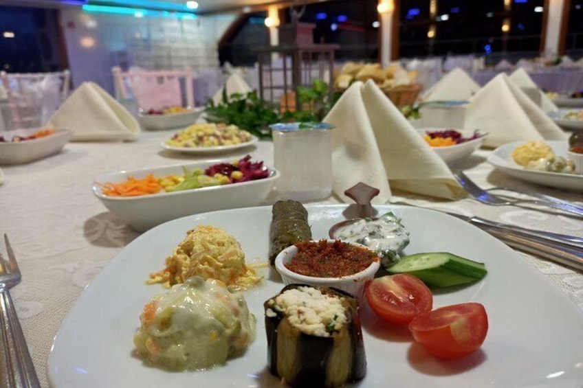 A table with various dishes including a salad, a rolled vegetable, and a small bowl of sauce. 4