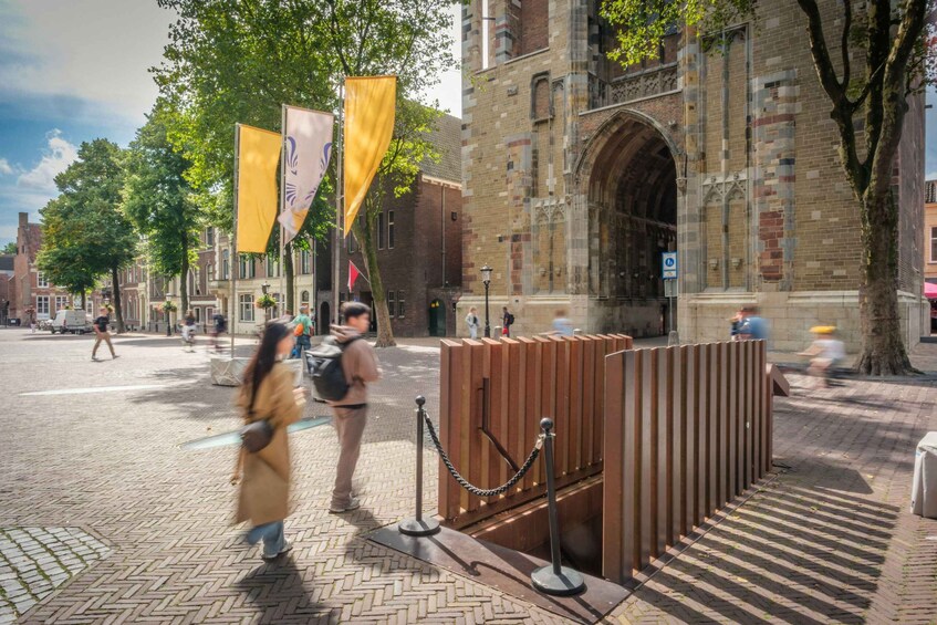 A historic building with a large arched entrance, surrounded by trees and a cobblestone street. 3