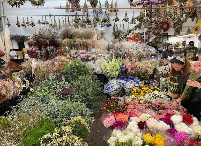 A flower market with various flowers and plants on display. 3