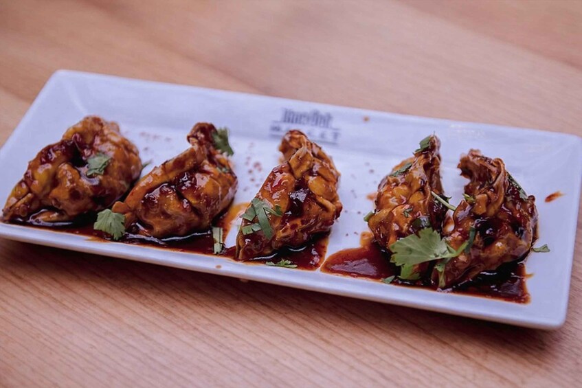 A dish of glazed chicken wings on a white plate. 1