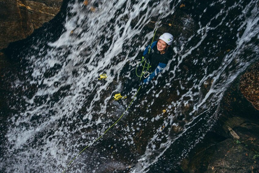 A person rappelling down a waterfall. 5