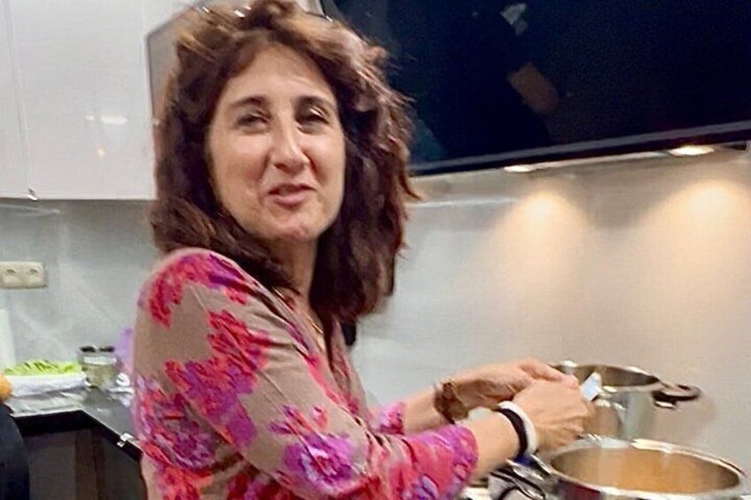 A person cooking in a kitchen with a pot on the stove. 4