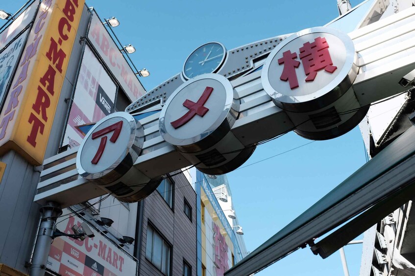 A street sign with multiple circular elements and a large vertical sign with 'ABC-MART' on it. 1