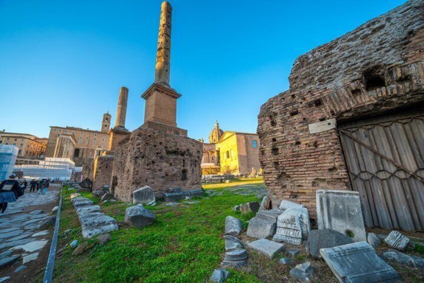 Ancient ruins with stone columns and a brick structure, surrounded by scattered gravestones. 4