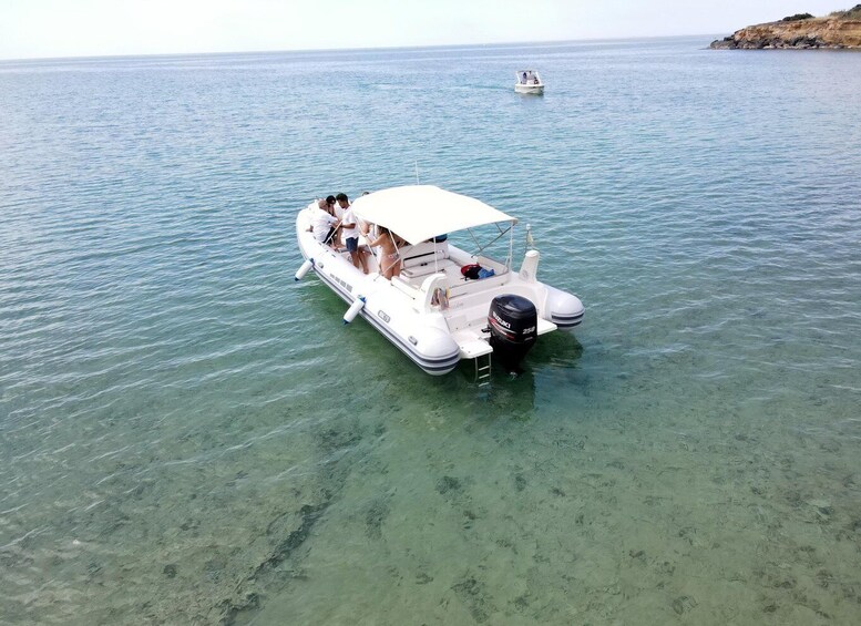 A white motorboat with passengers on a calm sea. 4