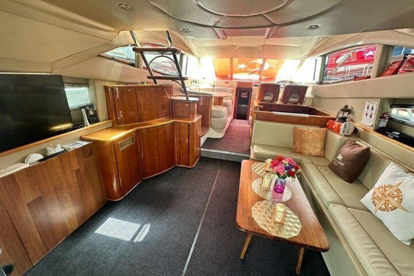 A yacht interior with a wooden bar, seating area, and a television. 5