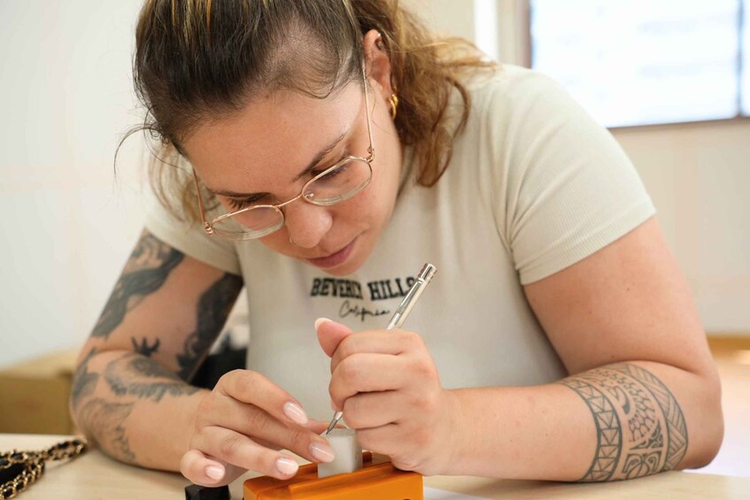 A person with tattoos on their arms writing with a pen. 1