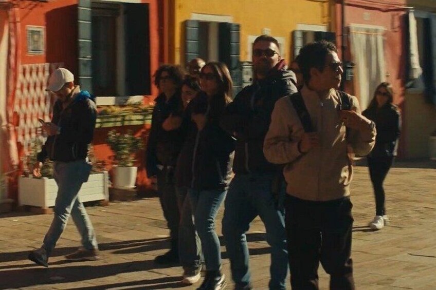 A group of people walking on a street with buildings in the background. 2