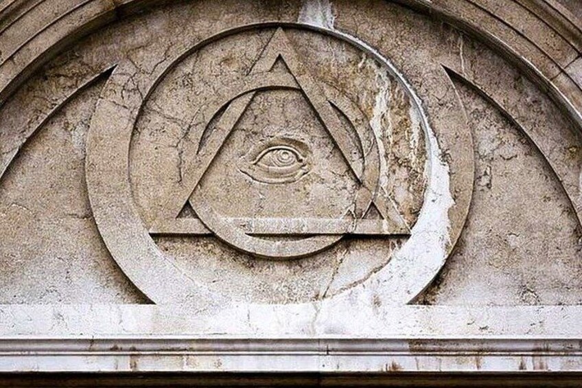 A stone relief with an eye within a triangle, surrounded by a circular design. 3