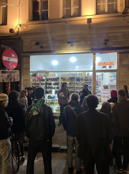 A nighttime outdoor market with people browsing and a store named 'GORDON' in the background. 5