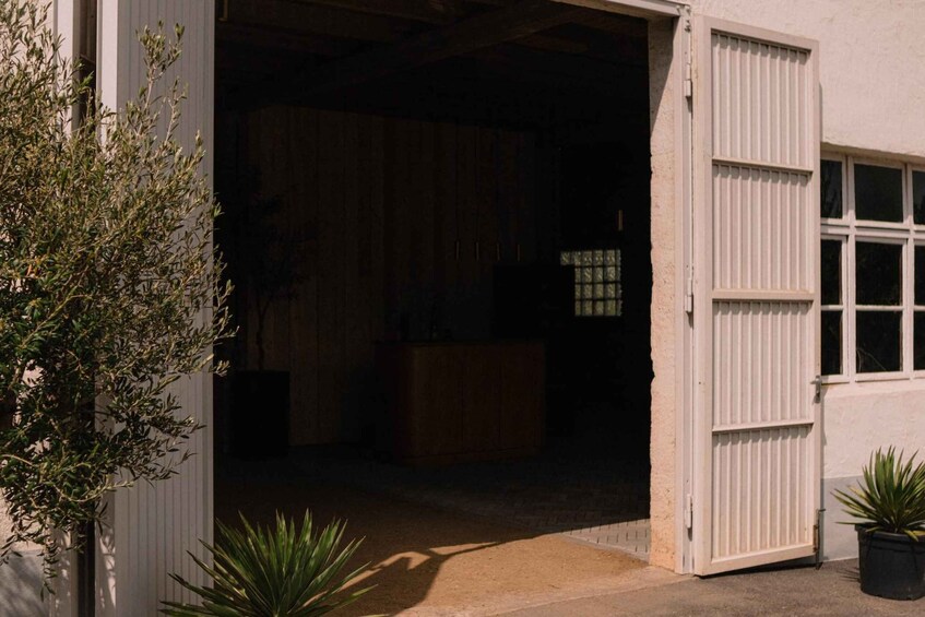 A garage door open, revealing a dark interior with a window and a door. 5