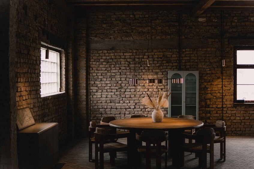 A rustic brick wall, a round wooden table with chairs, and a cabinet with glass doors. 1