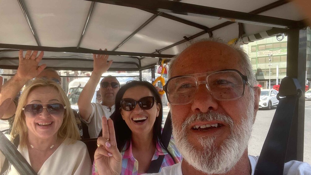 A group of people on a bus, with one person making a peace sign. 2