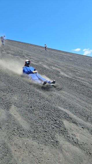 A person in blue gear sliding down a dirt slope. 2