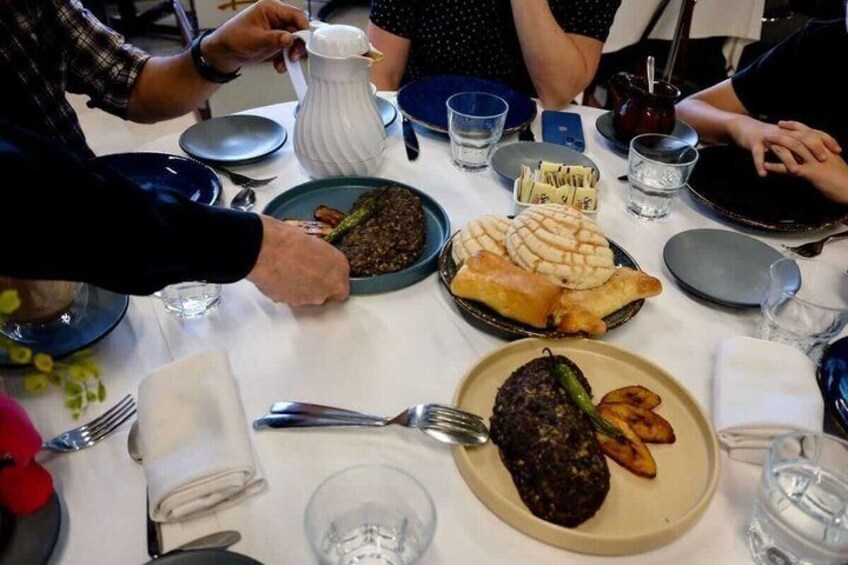 A dining table with various dishes, including a plate with a dark, round item and a plate with two round, flat items. 3