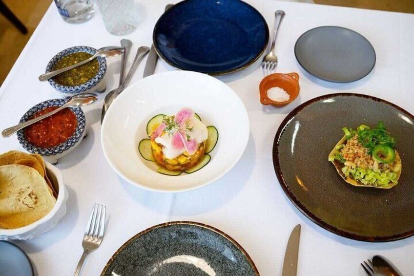 A table with various dishes, including a plate with a cucumber and radish salad, and another with a green vegetable dish. 4