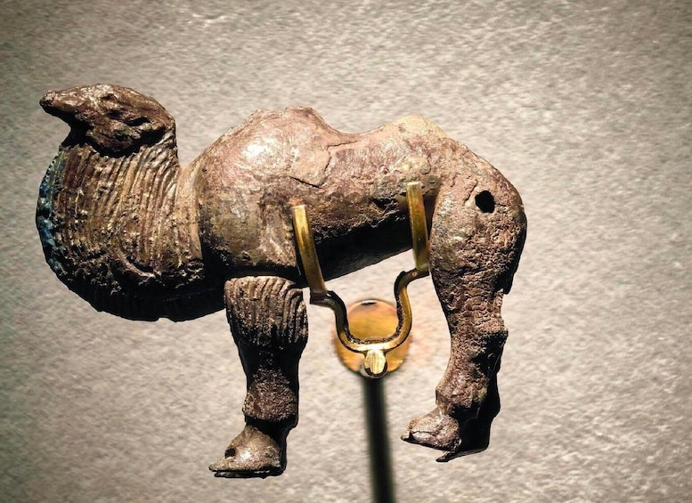 A bronze elephant figurine with a hook attached to its trunk. 5