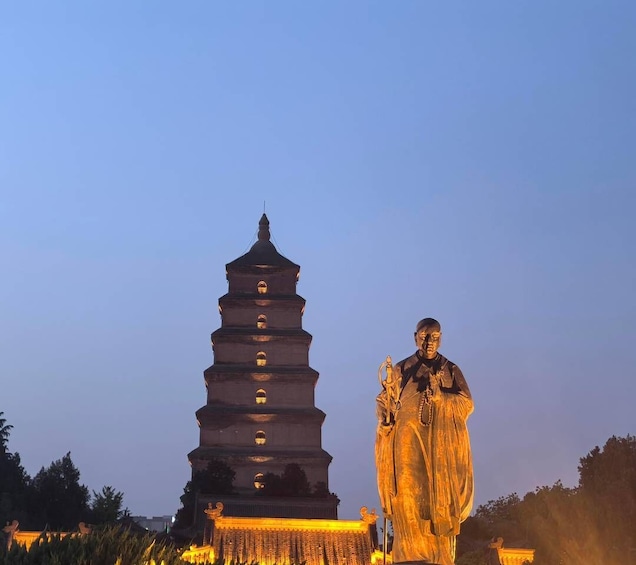 A pagoda and a statue at dusk. 3