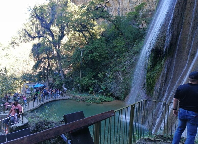 A waterfall, a bridge, and a crowd of people. 5