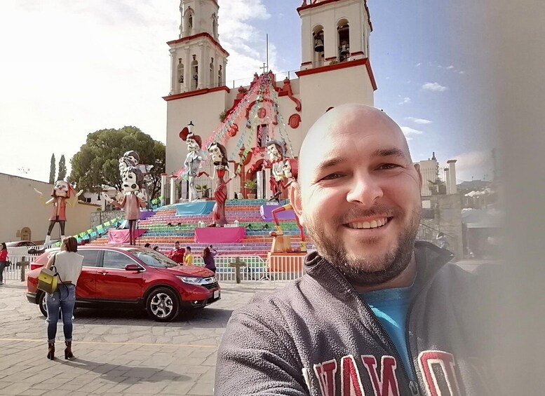 A man in front of a church with a colorful altar and a statue of a man and woman. 2