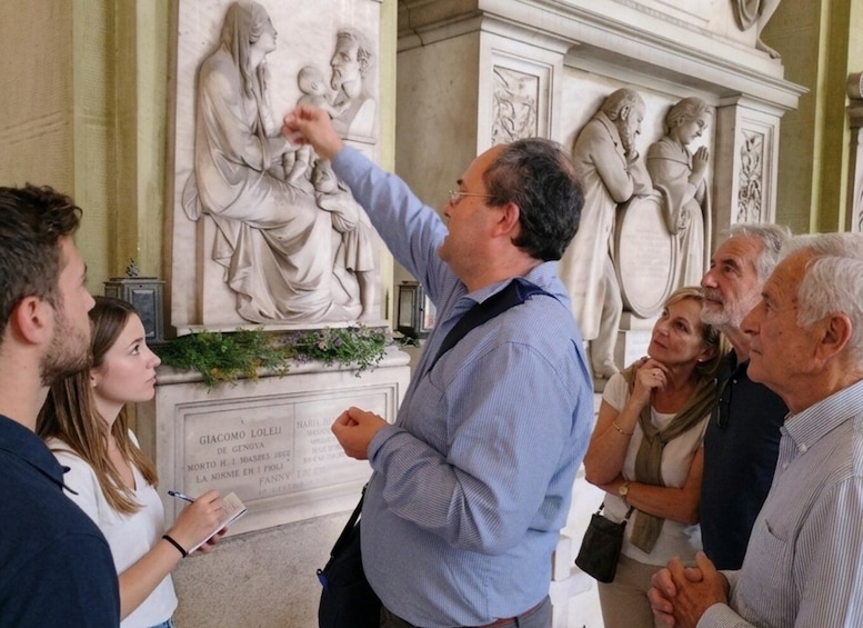 A group of people standing in front of a marble statue with inscriptions. 5