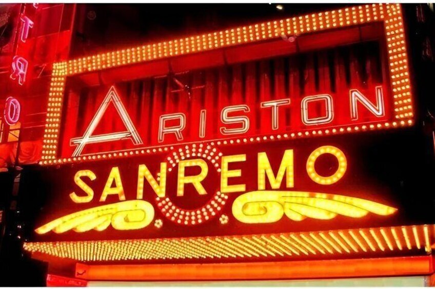 A neon sign with 'ARISTON SANREMO' in bright yellow letters. 4