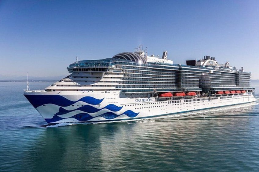 A large cruise ship with multiple decks and a distinctive blue and white design. 1