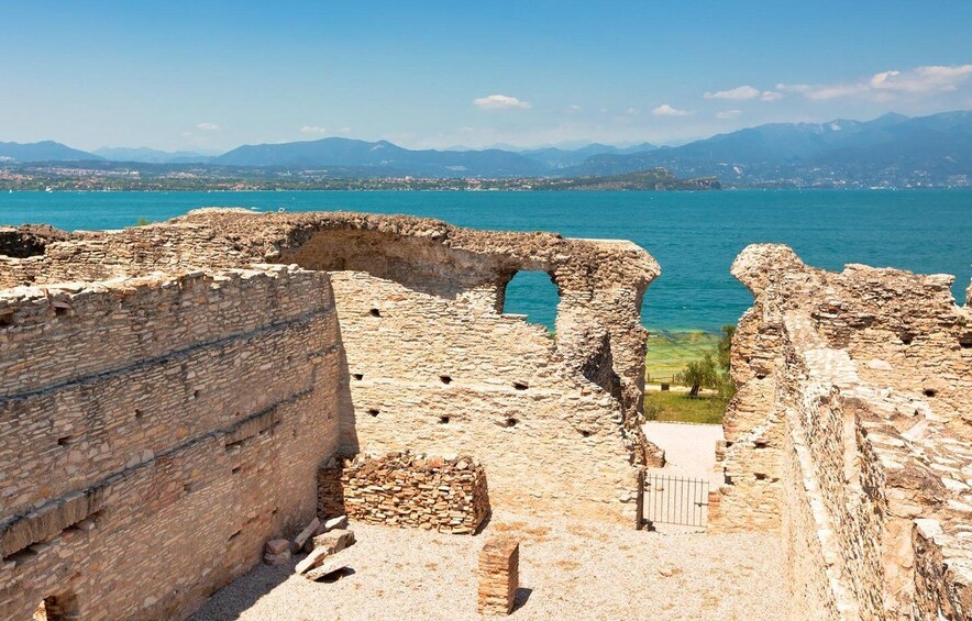 Ancient stone ruins with a view of a calm sea and distant mountains. 2