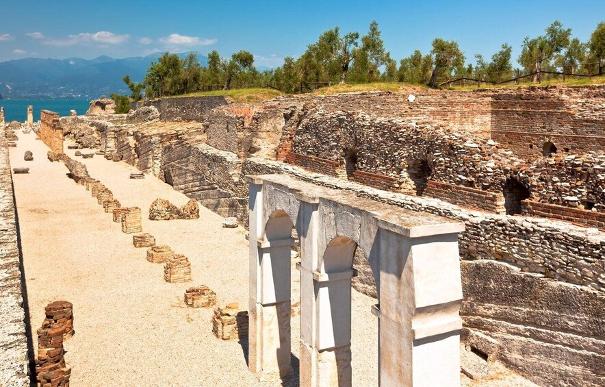 Ancient ruins with stone steps and arches, overlooking a coastal landscape. 1