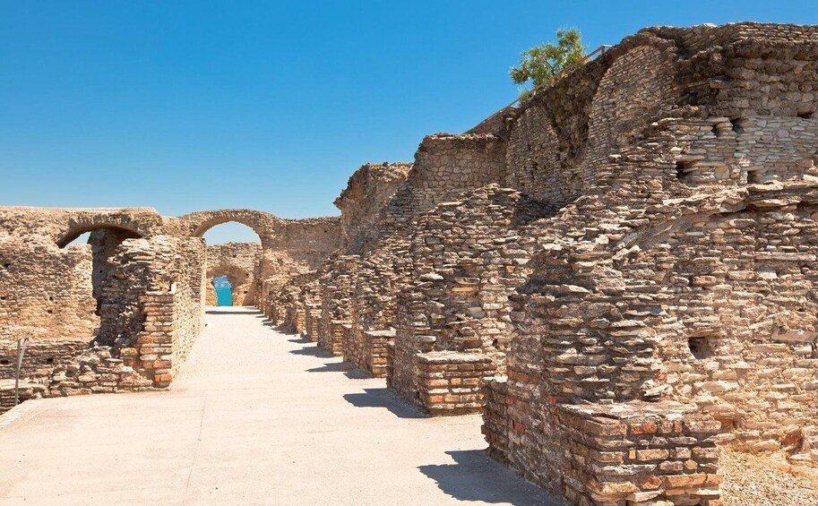 Ancient stone ruins with arches and a clear sky. 5