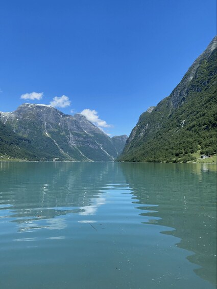 A calm lake surrounded by mountains with a clear sky. 3