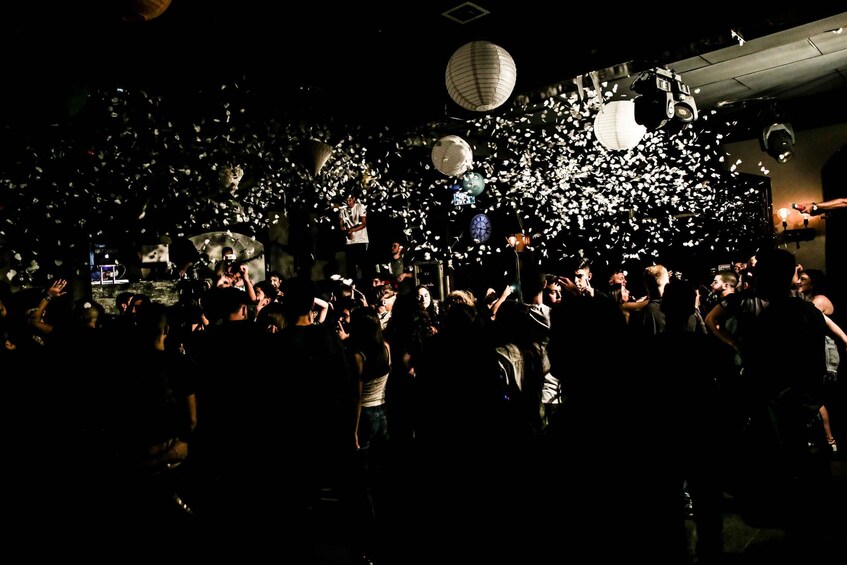 A crowded indoor event with hanging paper lanterns. 3