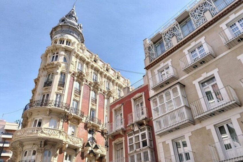 A historic building with ornate architecture, including a dome and decorative balconies. 3