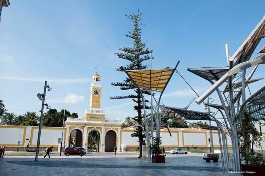 A mosque with a minaret, a large metal sculpture, and a clear blue sky. 2