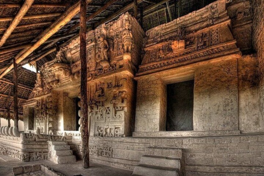 An ancient temple with intricate carvings and a thatched roof. 3